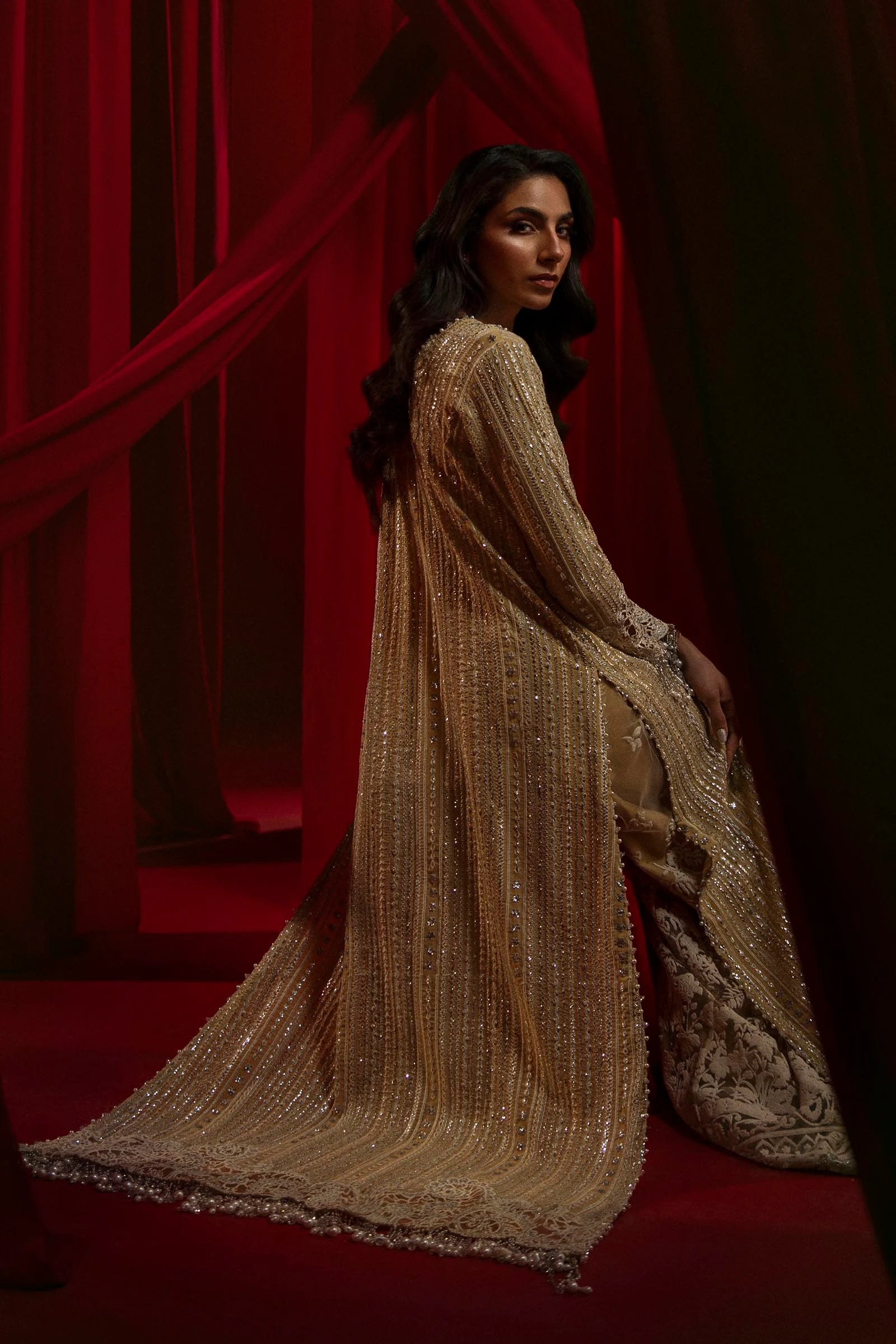 Model in Sana Safinaz gold NURA dress, highlighting luxury Pakistani attire for the UK market.