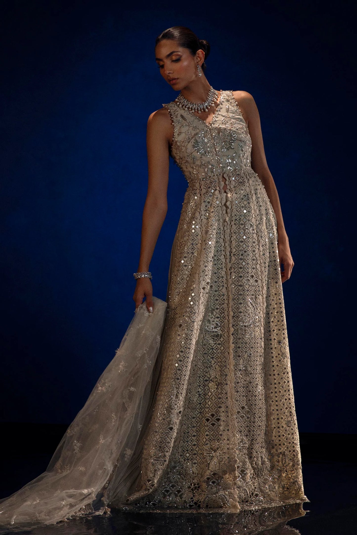 Model in Sana Safinaz silver NURA gown showcasing opulent Pakistani fashion in the UK.