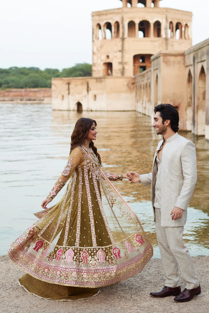 Model wearing Qalamkaar Shadmani Luxury Formals '24 Rameesha SH - 01 dress in olive green and deep red with intricate embroidery. Shop Pakistani bridal dresses online in the UK now.