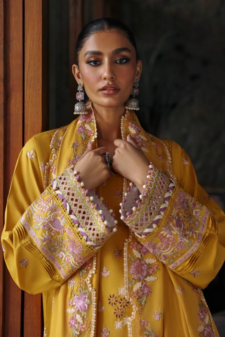 Model wearing LM - 04 SINSEAD dress from Qalamkar's Qlinekari Linen collection in mustard with intricate floral embroidery. Pakistani winter casual pret available online in the UK.