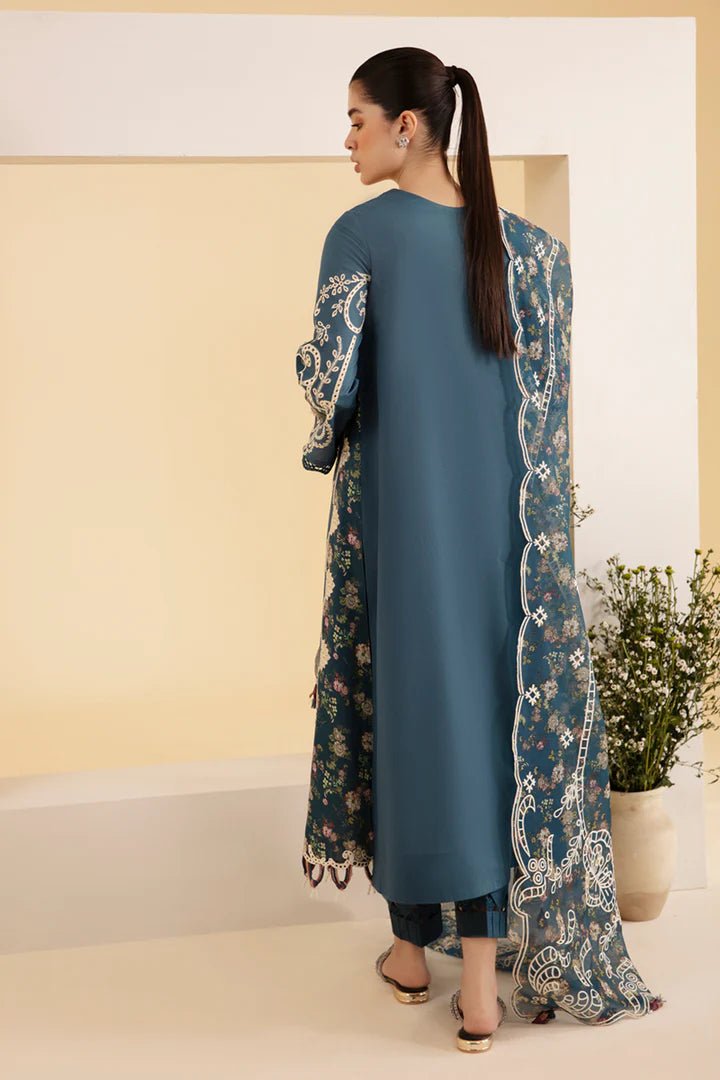 Model wearing blue SQ - 05 ELA dress from Qalamkar, featuring intricate embroidery and floral patterns. Ideal for Pakistani designer clothes in the UK, readymade clothing, and luxurious lawn collections.