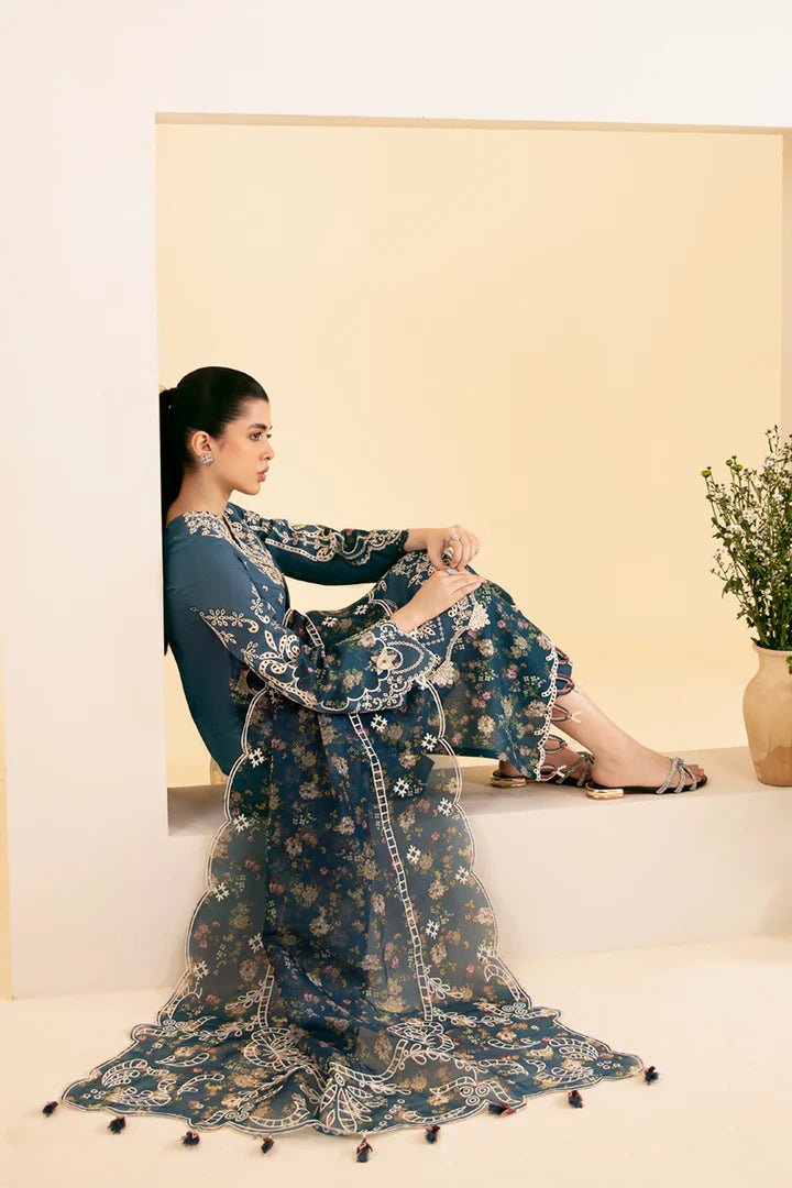 Model wearing blue SQ - 05 ELA dress from Qalamkar, featuring intricate embroidery and floral patterns. Ideal for Pakistani designer clothes in the UK, readymade clothing, and luxurious lawn collections.