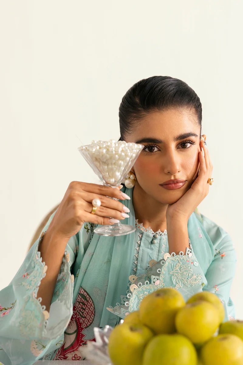 Model wearing Qalamkar Qprints '25 PQ - 08 Rena dress in pastel mint green with delicate floral embroidery. Shop Pakistani clothes online in the UK now.