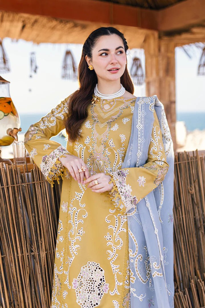 Model wearing mustard yellow FP - 03 SELMA dress with white and pastel embroidery, from Qalamkar, showcasing Pakistani lawn suits online in the UK.