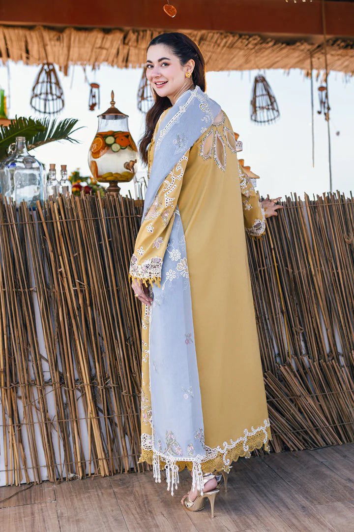 Model wearing mustard yellow FP - 03 SELMA dress with white and pastel embroidery, from Qalamkar, showcasing Pakistani lawn suits online in the UK.