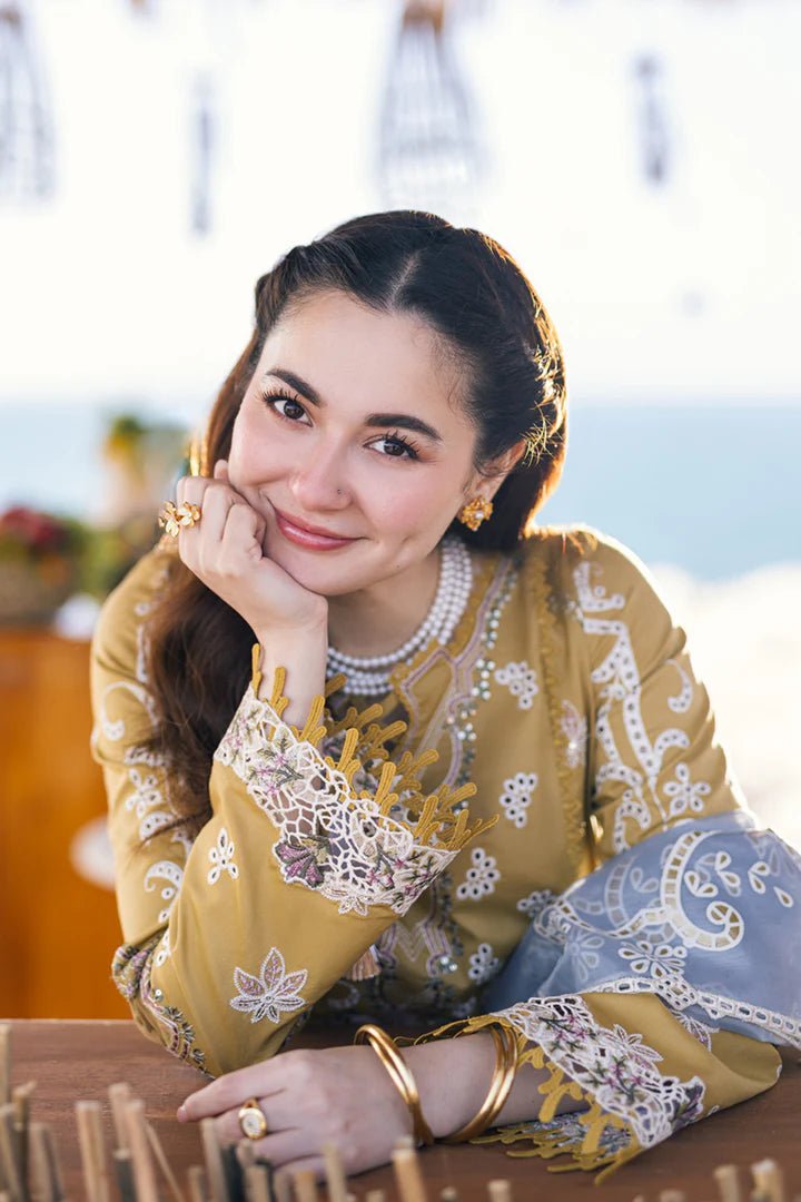 Model wearing mustard yellow FP - 03 SELMA dress with white and pastel embroidery, from Qalamkar, showcasing Pakistani lawn suits online in the UK.