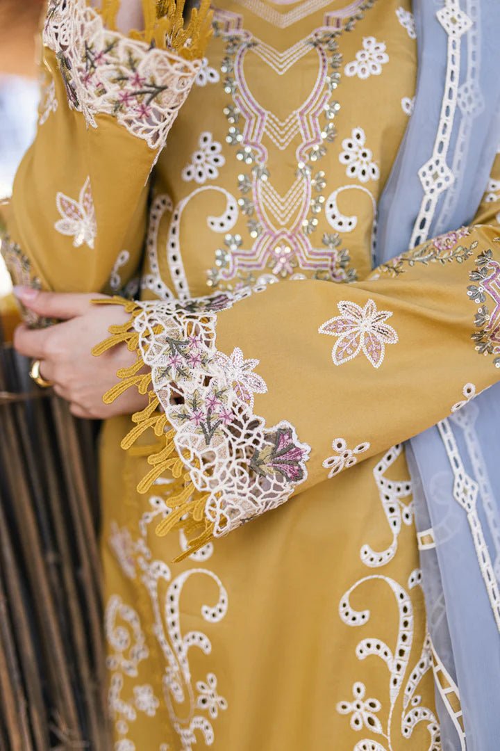 Model wearing mustard yellow FP - 03 SELMA dress with white and pastel embroidery, from Qalamkar, showcasing Pakistani lawn suits online in the UK.