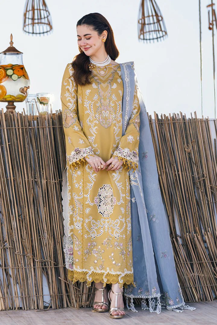 Model wearing mustard yellow FP - 03 SELMA dress with white and pastel embroidery, from Qalamkar, showcasing Pakistani lawn suits online in the UK.