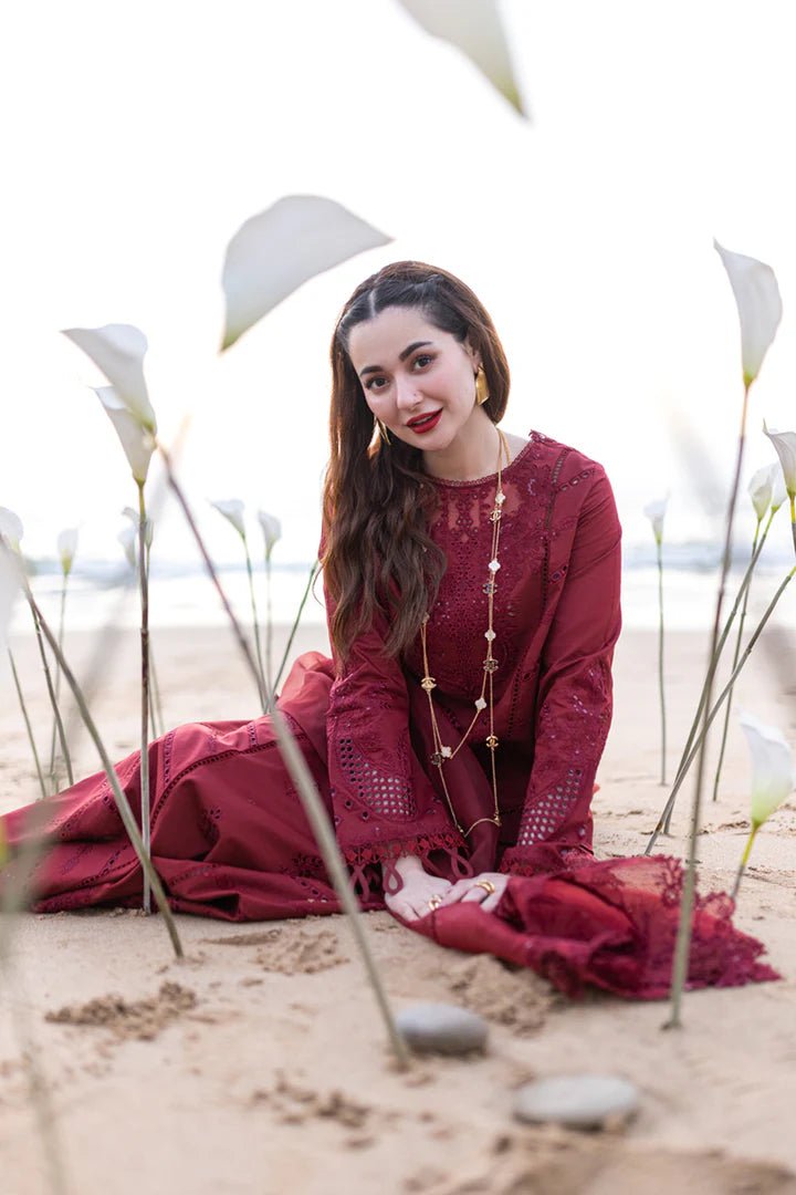 Model wearing maroon FP - 07 AISHA dress from Qalamkar by the beach. Highlighting Pakistani clothes online in UK, lawn suits, and luxury lawn 2024.