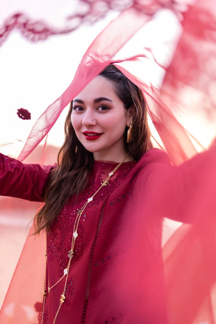 Model wearing maroon FP - 07 AISHA dress from Qalamkar by the beach. Highlighting Pakistani clothes online in UK, lawn suits, and luxury lawn 2024.