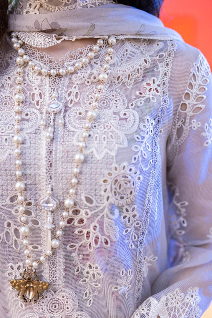 Model wearing Qalamkar's FP - 11 EMIRA dress in soft lavender with intricate embroidery, available in the UK. Ideal for luxury lawn suits and Pakistani clothes online.