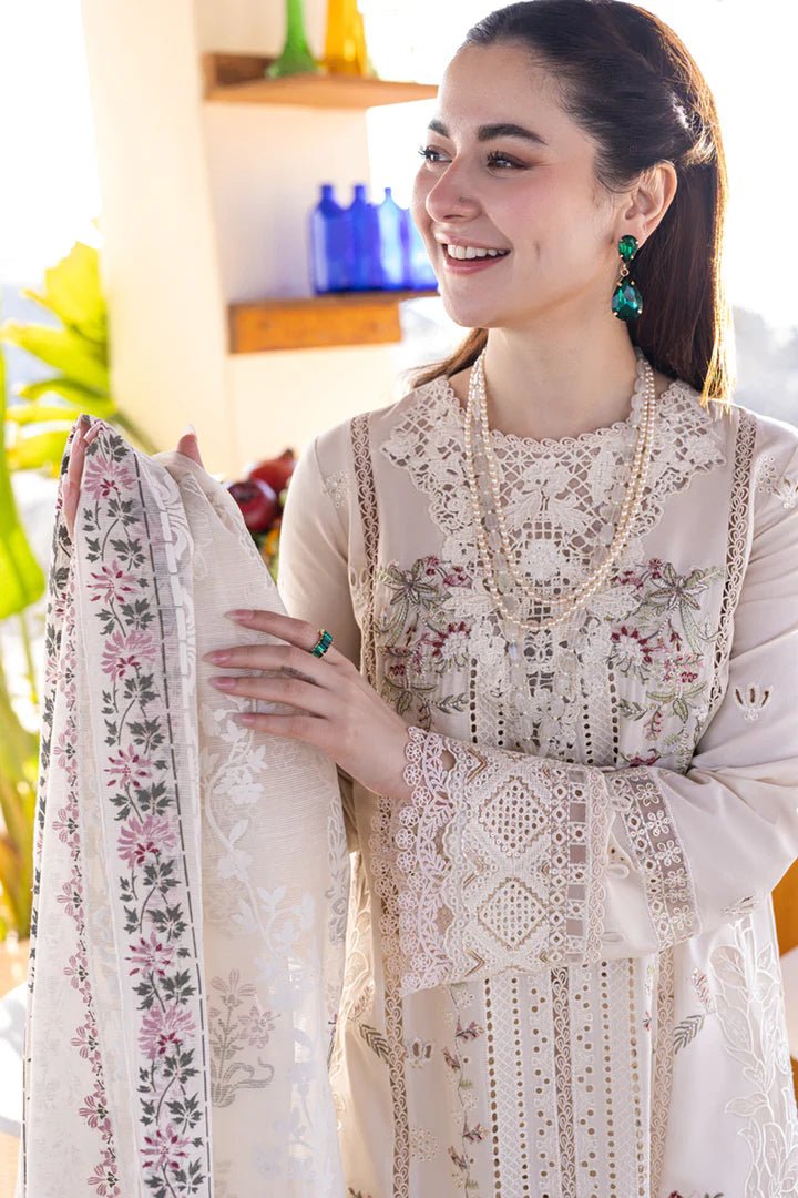 Model wearing a white FP - 12 MARWA dress from Qalamkar with intricate embroidery, standing against a beach background. Pakistani clothes online in UK, lawn suits.