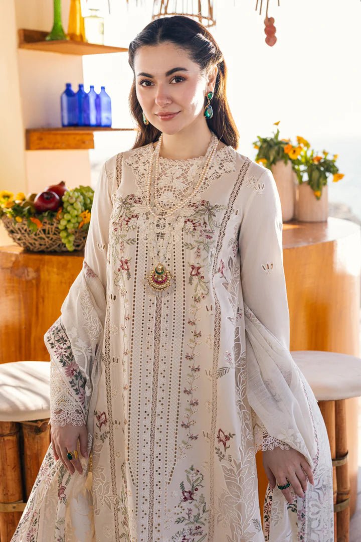 Model wearing a white FP - 12 MARWA dress from Qalamkar with intricate embroidery, standing against a beach background. Pakistani clothes online in UK, lawn suits.