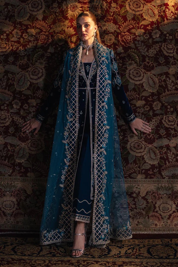 Model wearing Qalamkar Velvet Edit '24 BK - 07 LIYANA, a deep blue velvet dress adorned with intricate embroidery, ideal for weddings. Available as Pakistani clothes online in the UK.