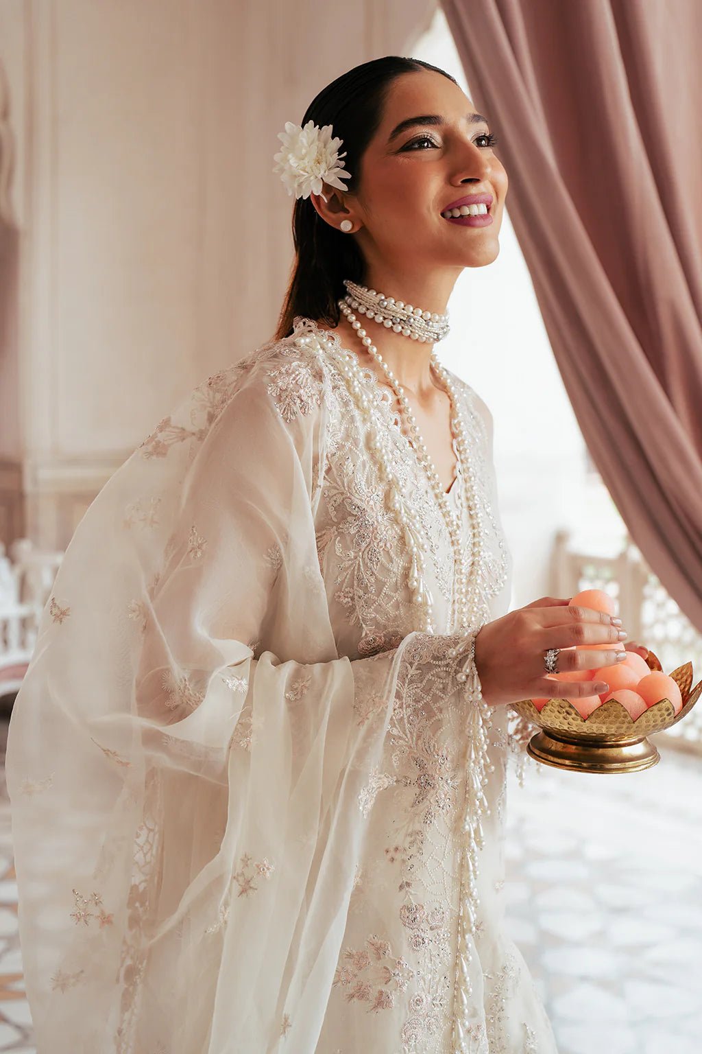 A model wearing an elegant off - white Saad Shiekh ensemble from collection Silsila with intricate organza embroidery, an embroidered dupatta with detailed pallu, and complementing raw silk trousers.