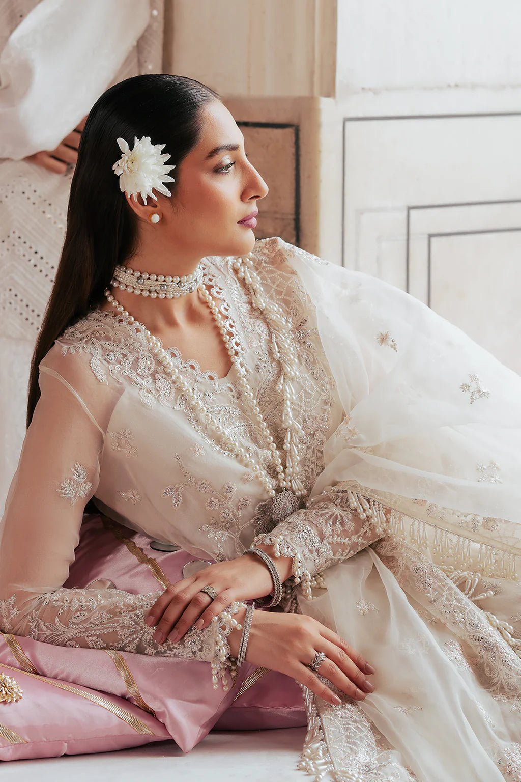 A model wearing an elegant off - white Saad Shiekh ensemble from collection Silsila with intricate organza embroidery, an embroidered dupatta with detailed pallu, and complementing raw silk trousers.