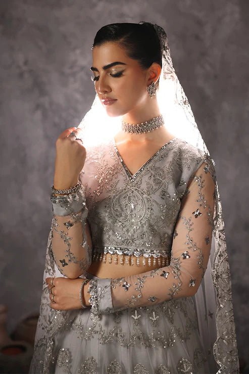 Model wearing Saffron Rang - e - Barq dress in shimmering silver from the Aatish Formals collection, ideal for Pakistani wedding clothes online in the UK.