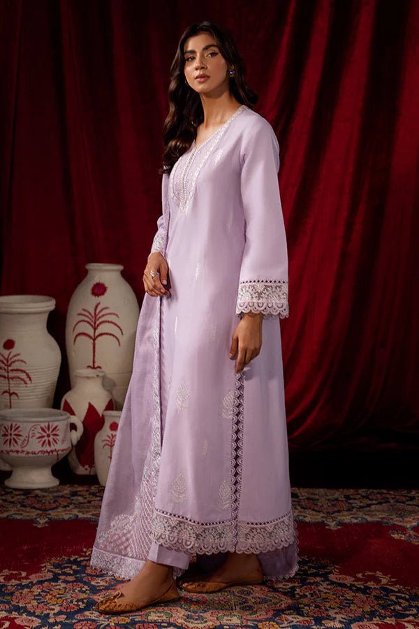 Model wearing Saffron Celestial Fall '24 LILY BLOOM, a pastel lilac outfit with delicate embroidery, ideal for winter. Available as Pakistani designer clothes online in the UK.