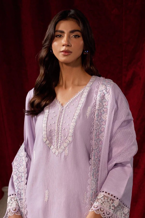 Model wearing Saffron Celestial Fall '24 LILY BLOOM, a pastel lilac outfit with delicate embroidery, ideal for winter. Available as Pakistani designer clothes online in the UK.