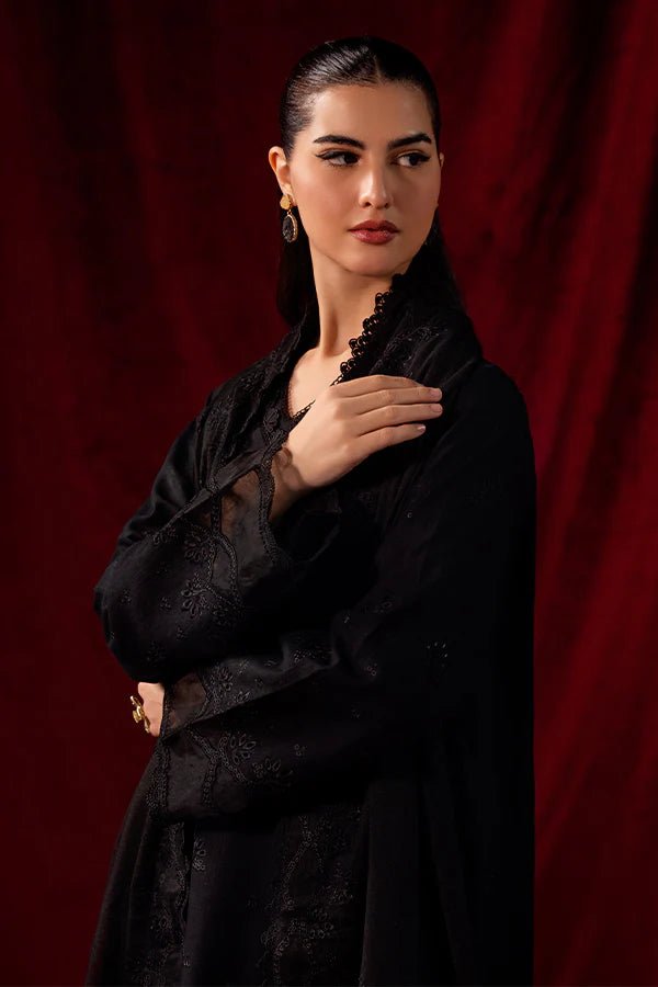 Model wearing Saffron Celestial Fall '24 MIDNIGHT ONYX, an elegant black outfit with intricate embroidery, perfect for winter. Available as Pakistani designer clothes online in the UK.