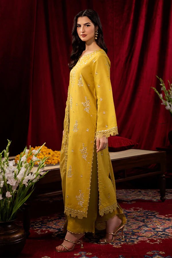 Model wearing a mustard yellow Tuscan Sunset dress from Saffron, detailed with embroidery, ideal for winter, showcasing Pakistani designer clothes online in the UK.