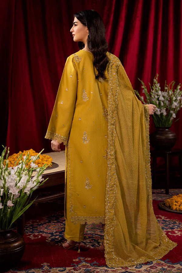 Model wearing a mustard yellow Tuscan Sunset dress from Saffron, detailed with embroidery, ideal for winter, showcasing Pakistani designer clothes online in the UK.