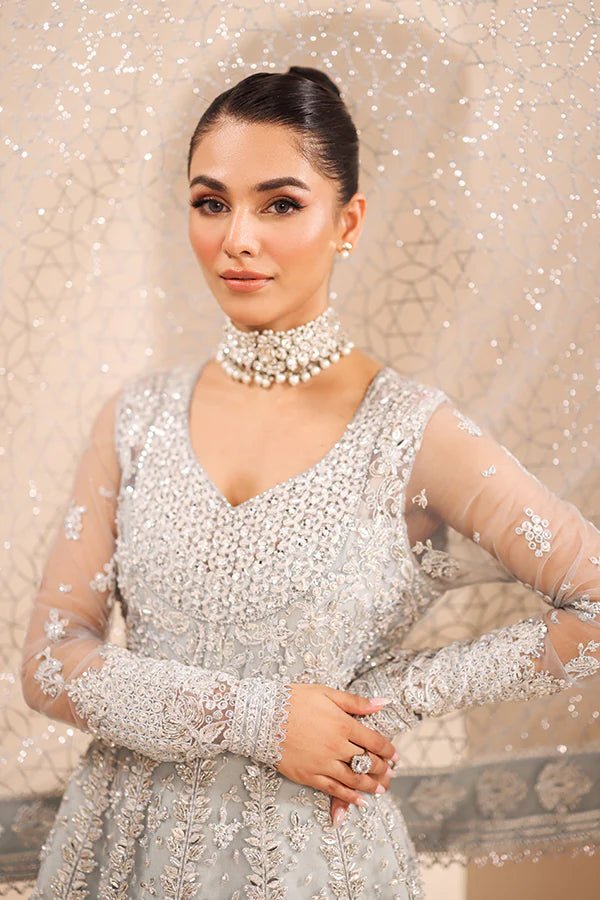 Model wearing 04 Silver Whisper from Saffron's Edel Formals Collection in elegant silver tones. Pakistani clothes online in UK at Signature Labels