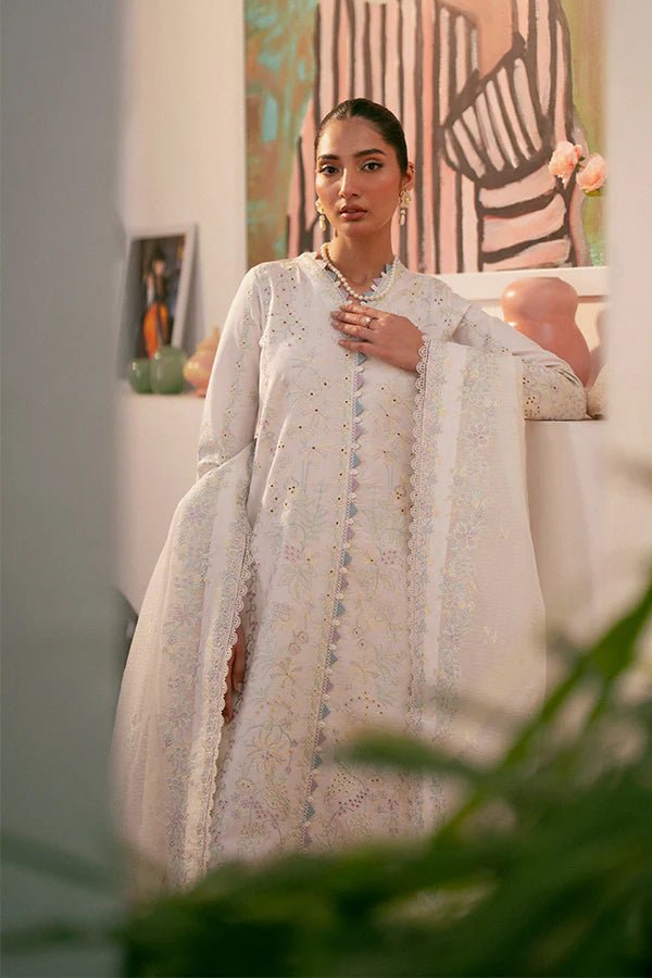 Model wearing white Liara dress from Saffron, featuring delicate embroidery. Ideal for Pakistani designer clothes in the UK, readymade clothes, and festive lawn collections.