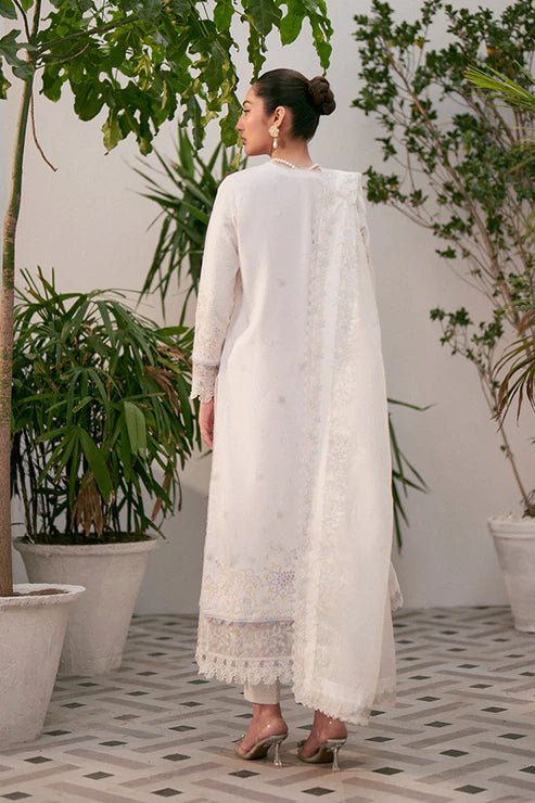 Model wearing white Liara dress from Saffron, featuring delicate embroidery. Ideal for Pakistani designer clothes in the UK, readymade clothes, and festive lawn collections.