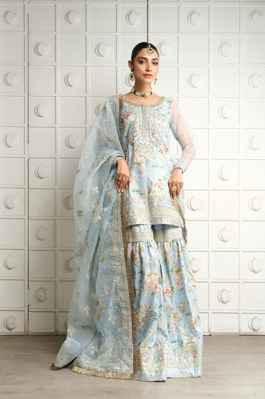 Model wearing SRN24 - 05 EDWINA dress in light blue with intricate floral embroidery from Saira Rizwan, showcasing Pakistani wedding clothes available online in the UK.