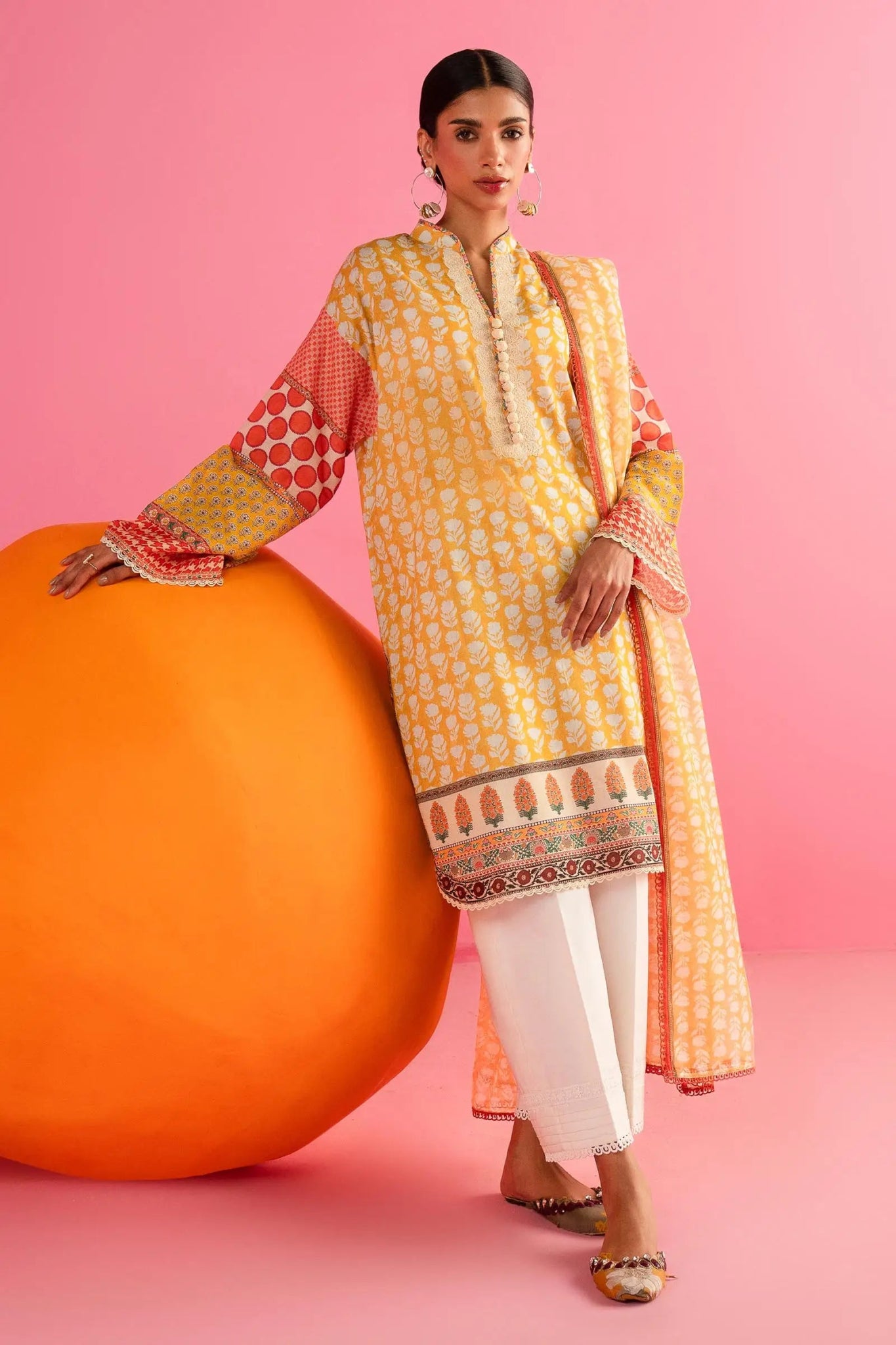 Model in Sana Safinaz 242 - 019A - 2DD yellow and red printed Pakistani lawn suit with white pants.