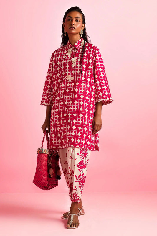 Model wearing Sana Safinaz Mahay'24 red geometric lawn dress, vibrant summer style in UK.