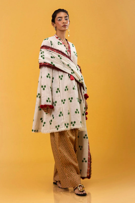 Model wearing Sana Safinaz Mahay Winter '24, showcasing a white and yellow with hues of green 3 - piece outfit with embroidery and intricate printing, ideal for winter casual pret. Available online in the UK.