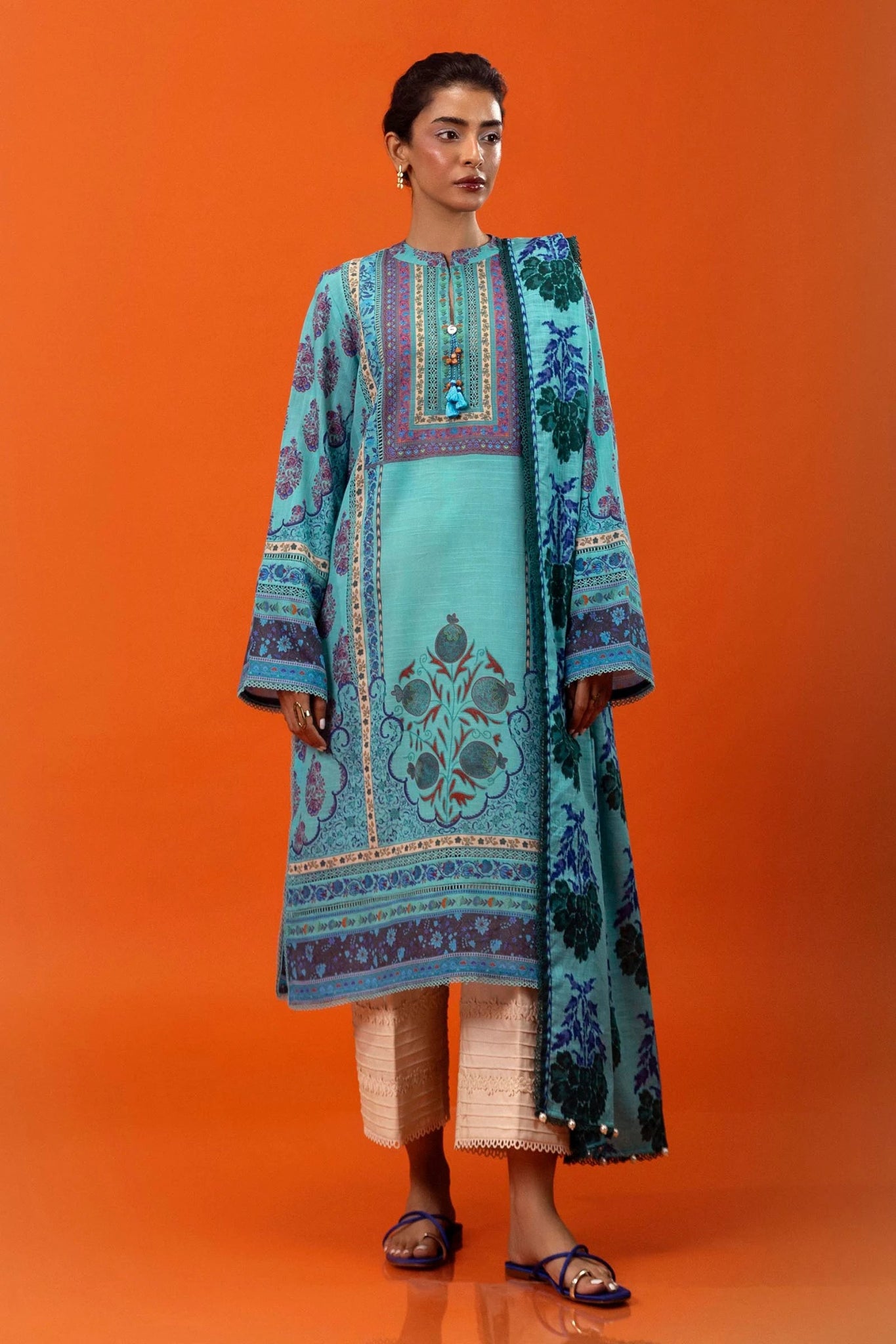 Model wearing Sana Safinaz Mahay Winter '24, showcasing a blue 2 - piece outfit with intricate printing om khaddar, ideal for winter casual pret. Available online in the UK.