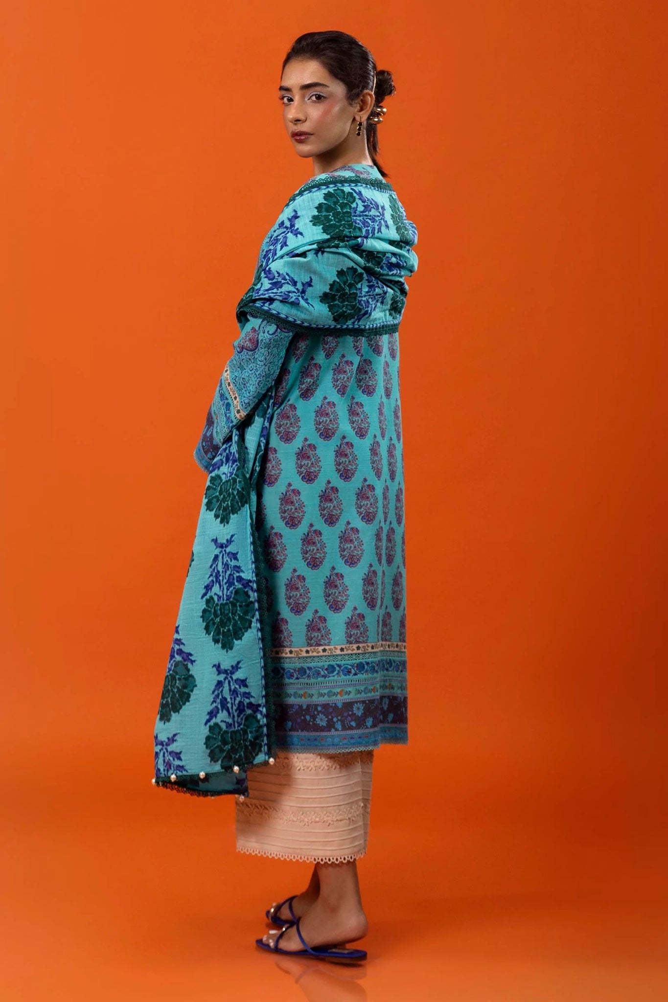 Model wearing Sana Safinaz Mahay Winter '24, showcasing a blue 2 - piece outfit with intricate printing om khaddar, ideal for winter casual pret. Available online in the UK.