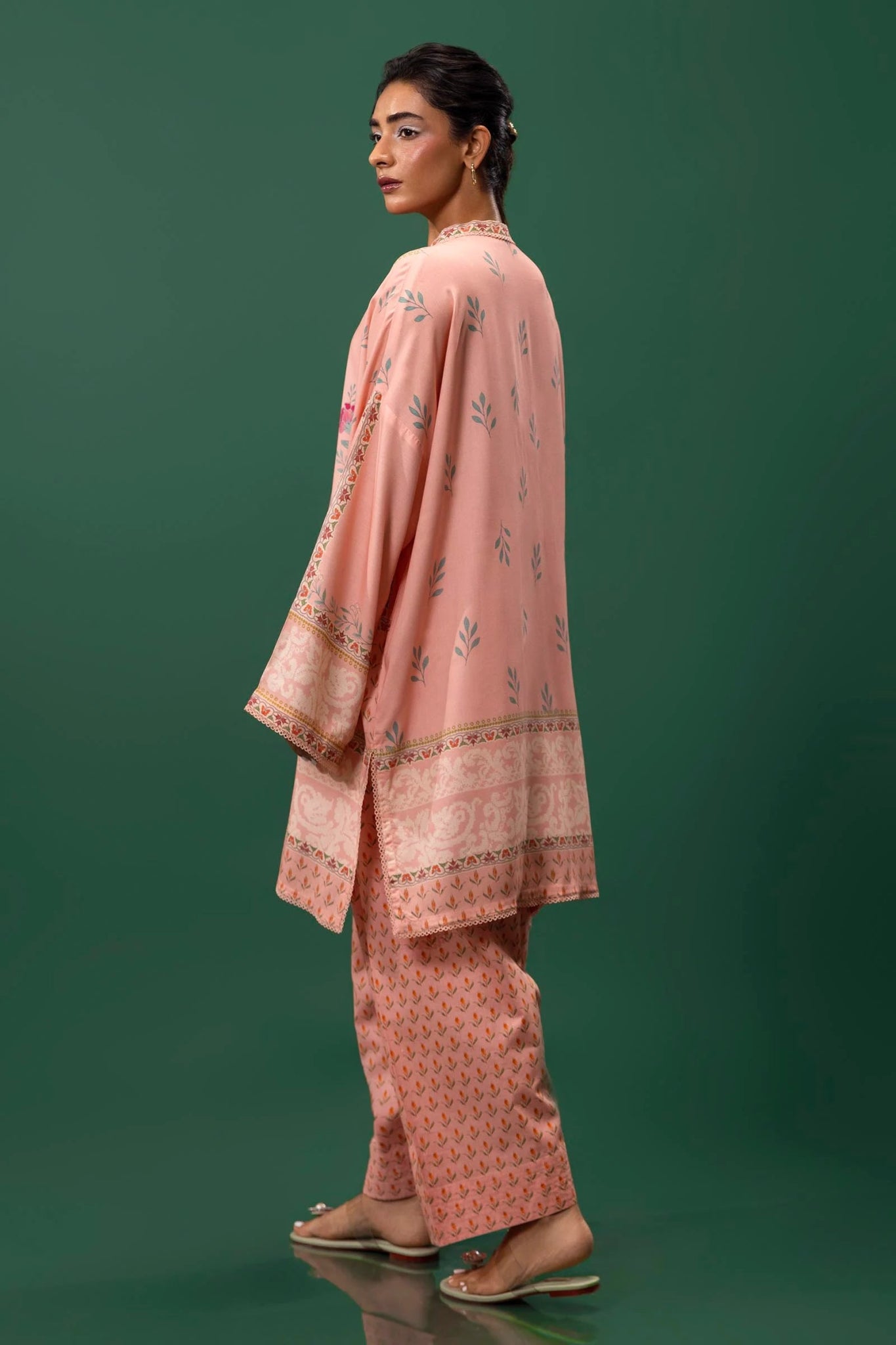 Model wearing a two - piece Sana Safinaz suit from Mahay Winter '24 in peach, featuring floral digital prints, embroidered organza patti, and matching cambric pants. Available online in the UK