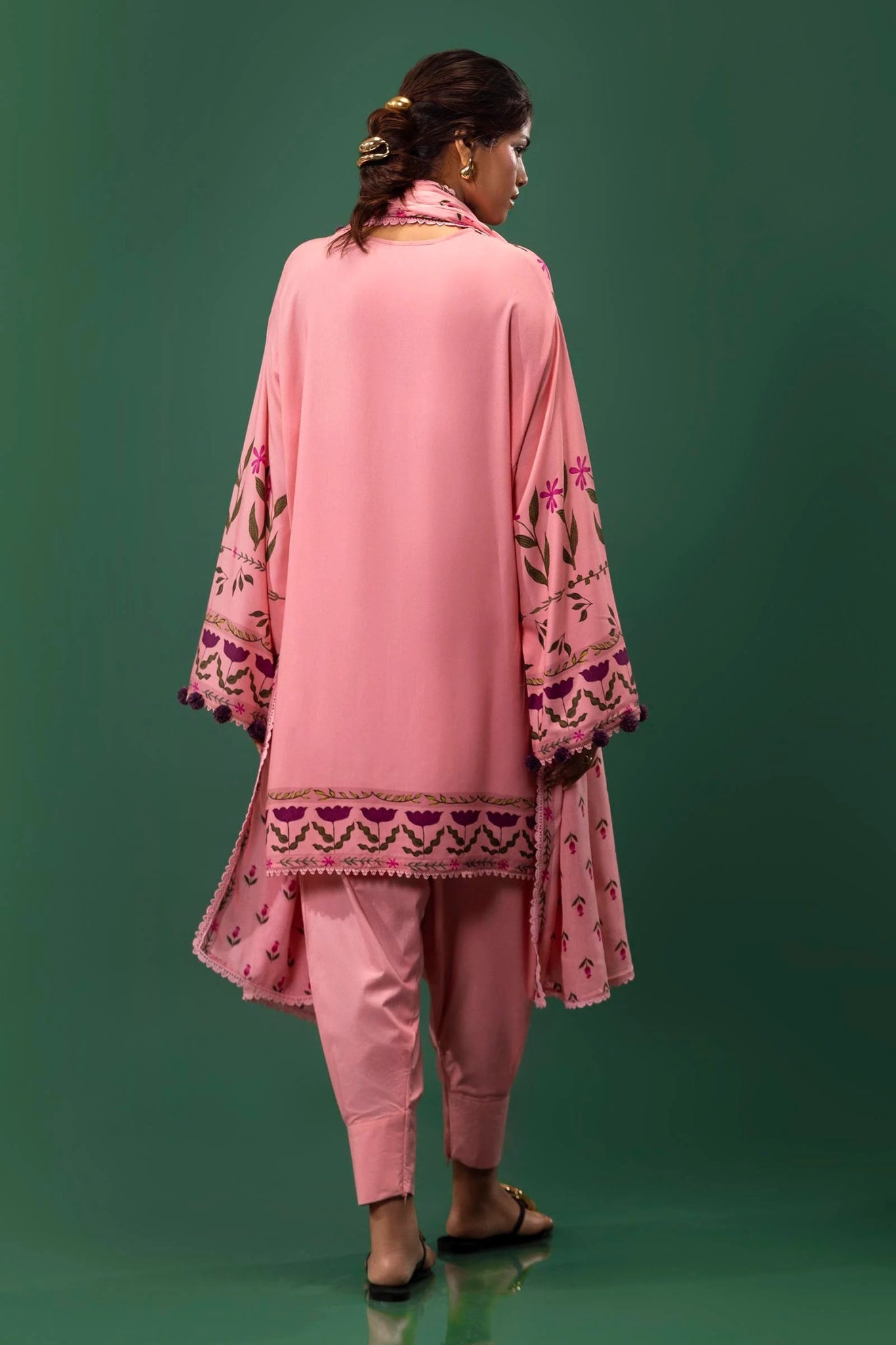 Model wearing a three - piece Sana Safinaz suit from Mahay Winter '24 in pink, featuring digital prints on linen, a printed dupatta, and dyed cambric pants. Available online in the UK