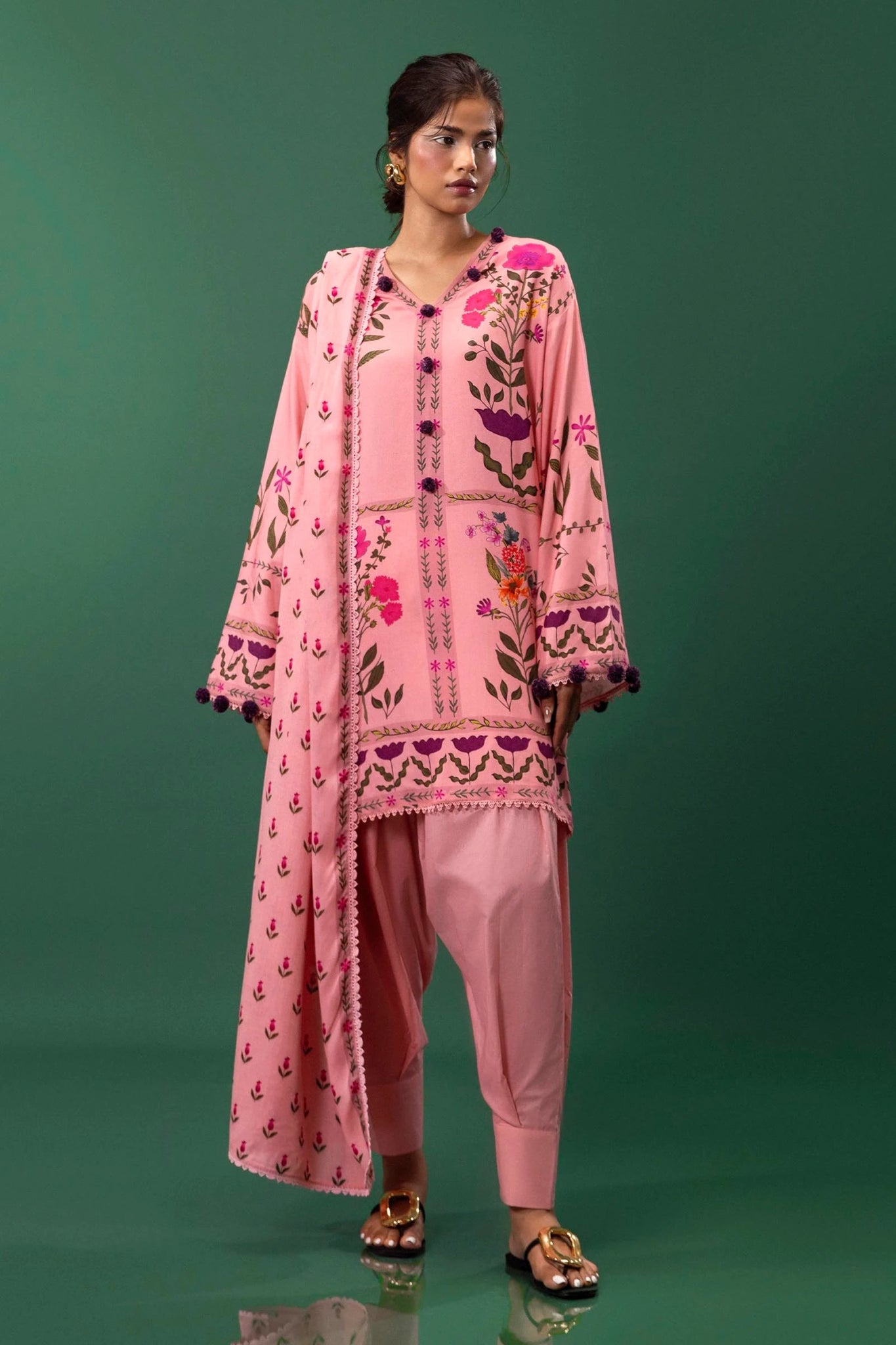 Model wearing a three - piece Sana Safinaz suit from Mahay Winter '24 in pink, featuring digital prints on linen, a printed dupatta, and dyed cambric pants. Available online in the UK