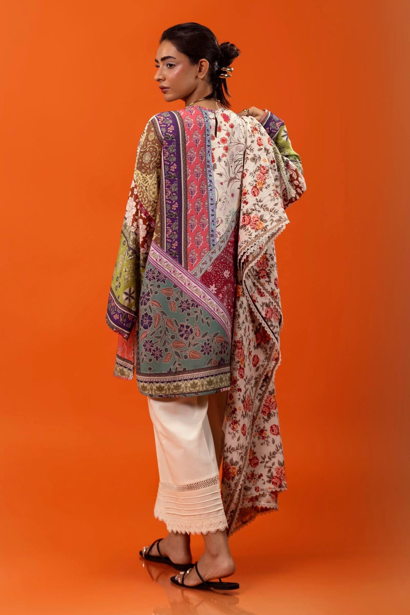 Model wearing a two - piece Sana Safinaz suit from Mahay Winter '24 featuring a digitally printed linen shirt with vibrant floral and geometric patterns, paired with a coordinating rotary printed linen dupatta. Available online in the UK.