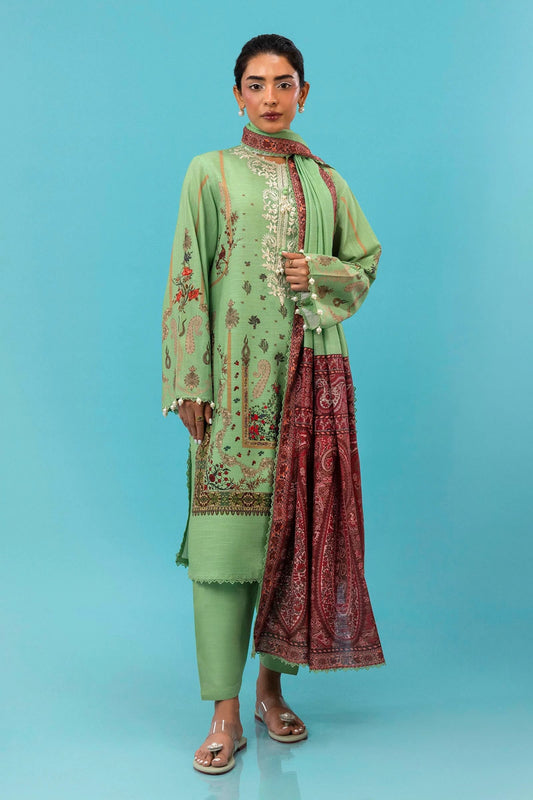 A model is wearing a three - piece outfit from the Mahay Winter '24 collection by Sana Safinaz. This ensemble includes a digitally printed slub shirt with coordinated front, back, and sleeves, and an embroidered organza neckline for added elegance. It is paired with dyed cambric pants and a digitally printed khaddar dupatta, completing the look with rich patterns. Ideal for women seeking premium Pakistani fashion, this outfit is available online in the UK for £64.00.