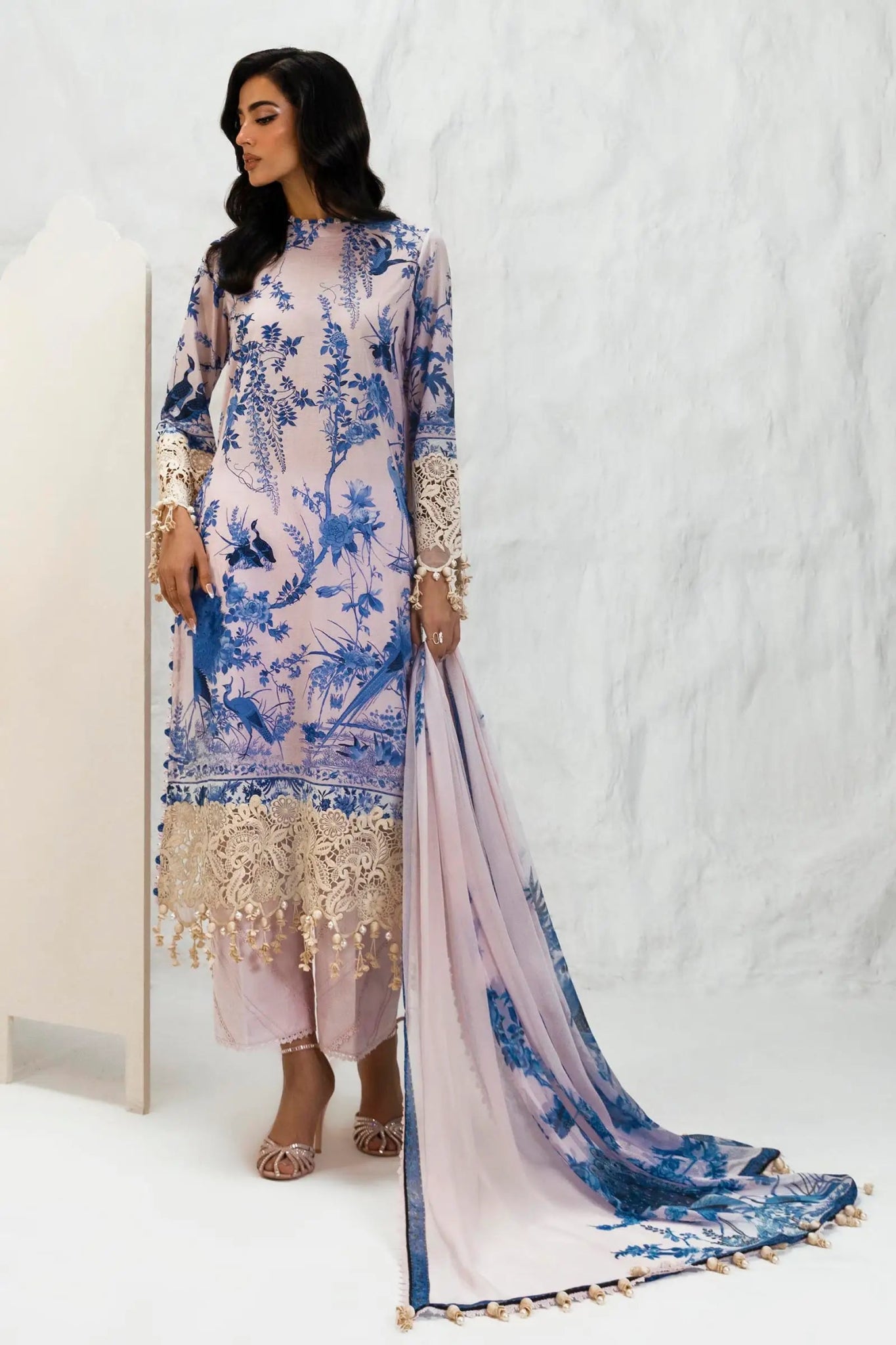 Model wearing Sana Safinaz M242 - 004B - CI pastel lavender dress with intricate blue floral patterns and cream lace trim, perfect for Pakistani designer clothes in the UK, readymade lawn suits.