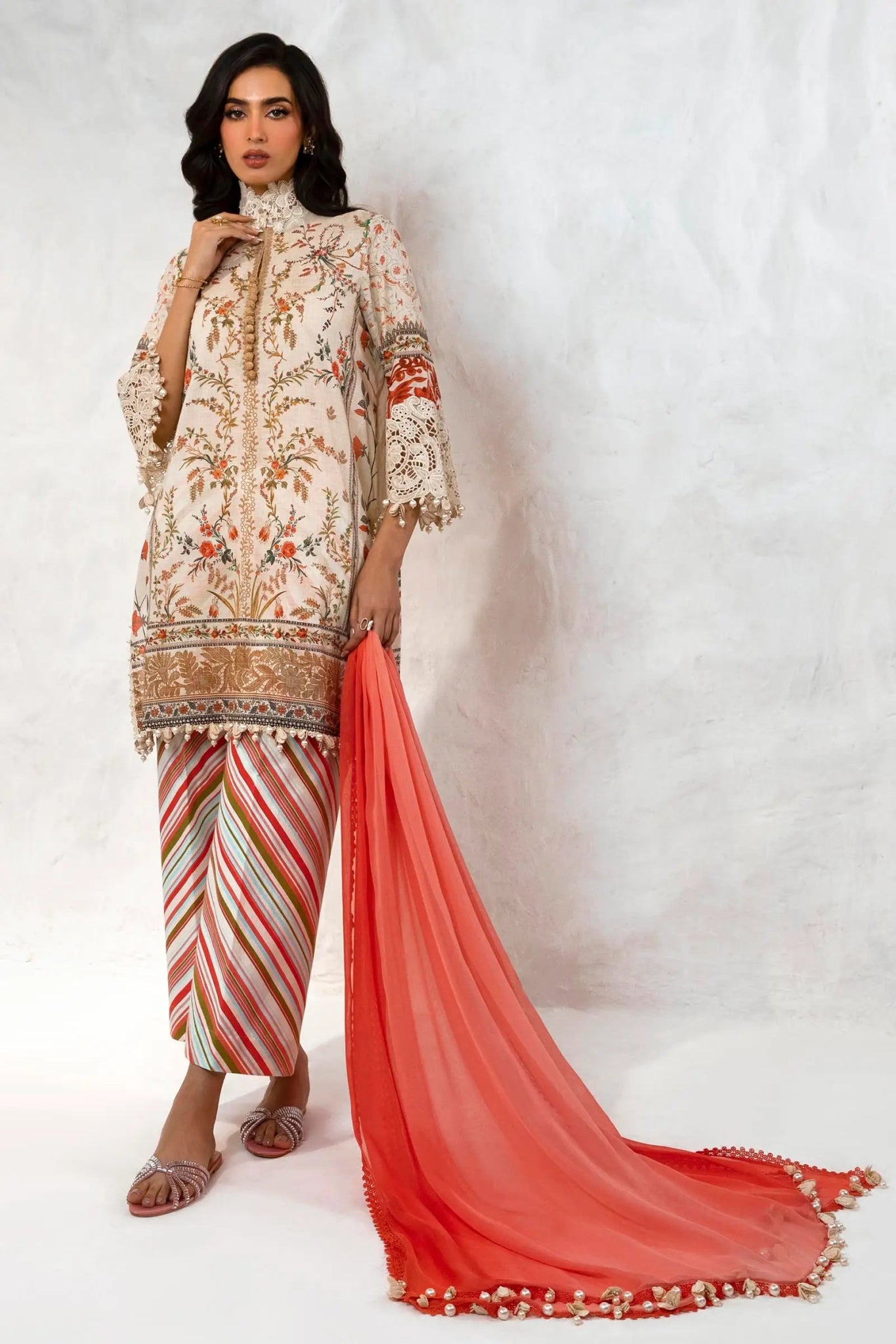 Model wearing Sana Safinaz M242 - 005A - CI cream dress with vibrant floral embroidery and striped pants, perfect for Pakistani designer clothes in the UK, readymade lawn suits.