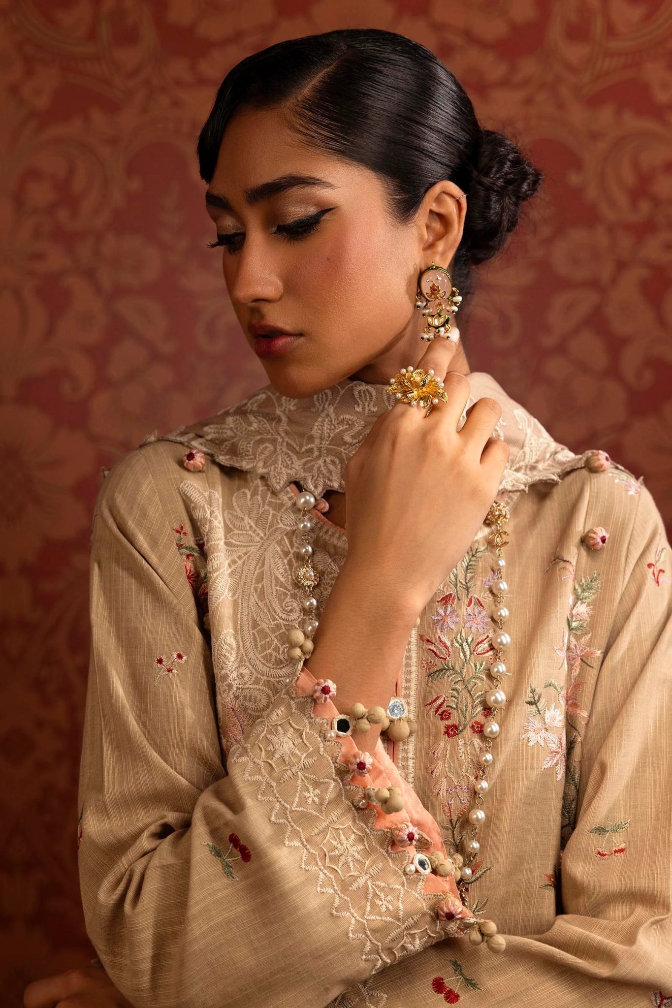 A model wears a three - piece Sana Safinaz outfit from the Muzlin Winter '24 Collection. It features embroidered front panels and sleeves on slub, a matching embroidered shawl with a detailed pallu, and dyed cotton pants. Perfect for women seeking elegant Pakistani designer wear. Available online in the UK.