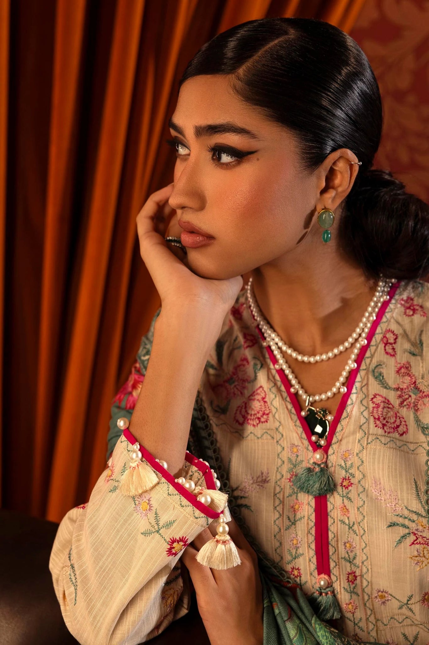 Model wearing a 3 - piece off - white embroidered suit featuring a slub front kali, embroidered sleeves, and a digitally printed shawl with vibrant patterns. Paired with dyed cotton pants, styled gracefully. Part of the Sana Safinaz Muzlin Winter 2024 collection, available online in the UK."