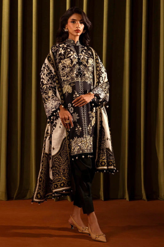 Model wearing a 3 - piece black suit featuring a digitally printed linen front, back, and sleeves with intricate beige floral patterns. Styled with an embroidered organza neckline and border, a printed khaddar dupatta, and dyed cotton pants for an elegant look. Part of the Sana Safinaz Muzlin Winter 2024 collection, available online in the UK.