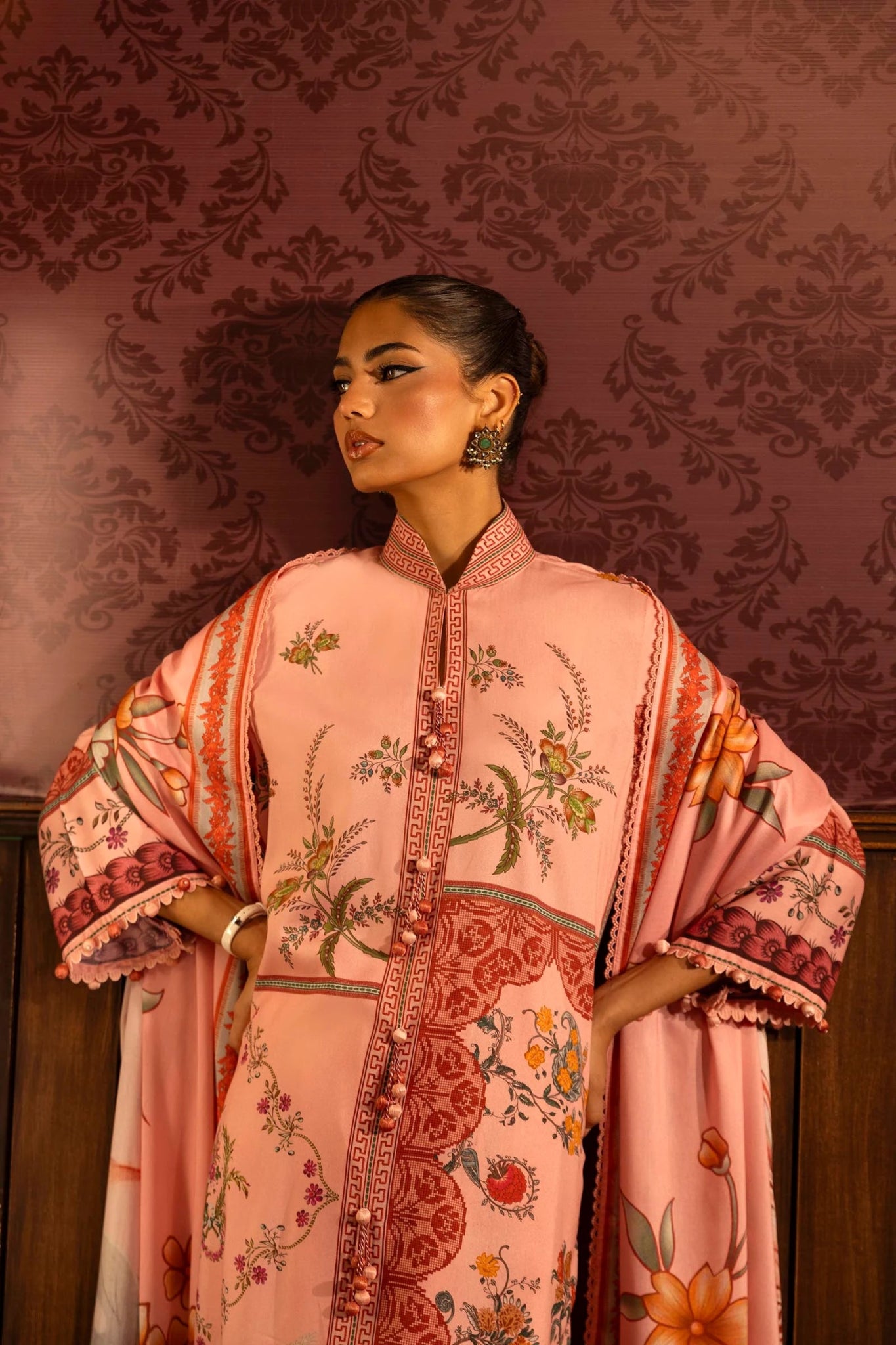 A stylish 3 - piece suit by Sana Safinaz in pink, featuring a digitally printed linen shirt with intricate embroidered organza borders, paired with dyed cotton pants and a floral printed linen dupatta. Perfect for an elegant winter wardrobe. Available online in the UK.