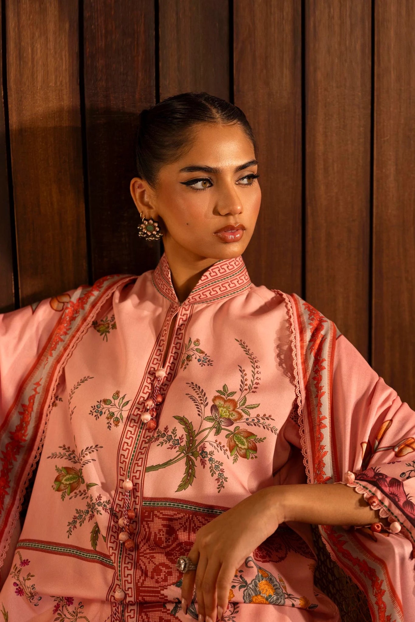 A stylish 3 - piece suit by Sana Safinaz in pink, featuring a digitally printed linen shirt with intricate embroidered organza borders, paired with dyed cotton pants and a floral printed linen dupatta. Perfect for an elegant winter wardrobe. Available online in the UK.