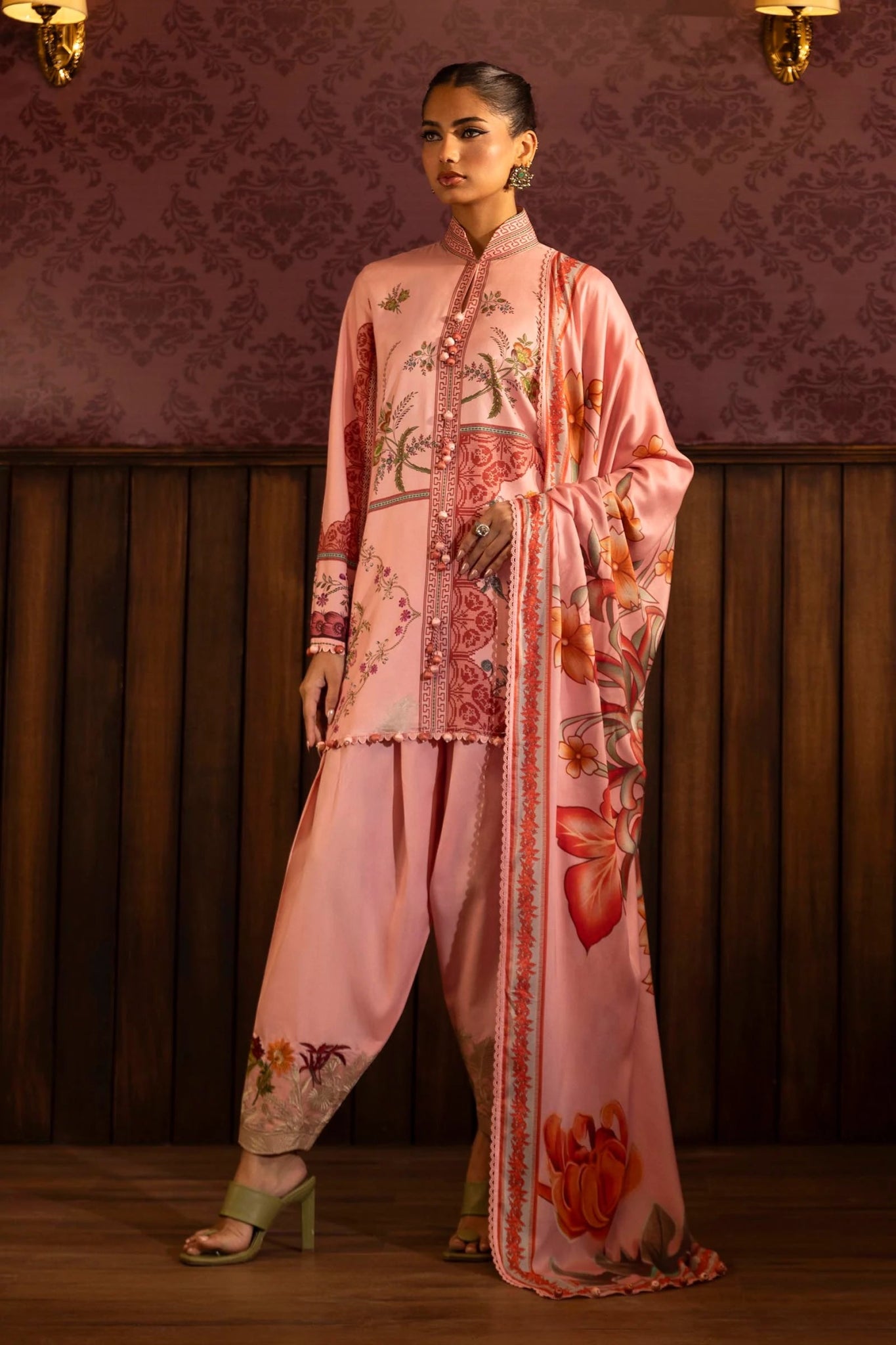 A stylish 3 - piece suit by Sana Safinaz in pink, featuring a digitally printed linen shirt with intricate embroidered organza borders, paired with dyed cotton pants and a floral printed linen dupatta. Perfect for an elegant winter wardrobe. Available online in the UK.