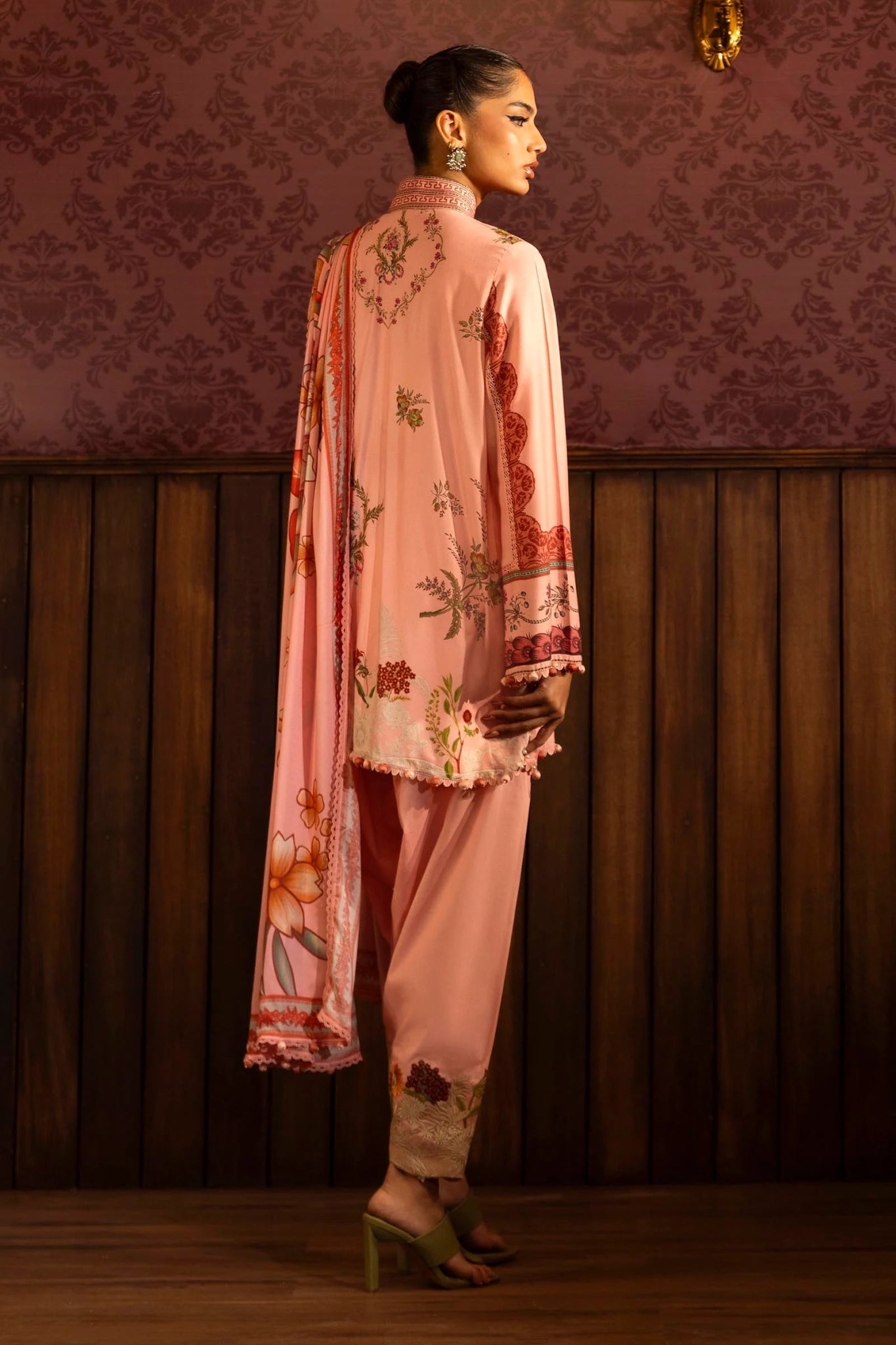 A stylish 3 - piece suit by Sana Safinaz in pink, featuring a digitally printed linen shirt with intricate embroidered organza borders, paired with dyed cotton pants and a floral printed linen dupatta. Perfect for an elegant winter wardrobe. Available online in the UK.