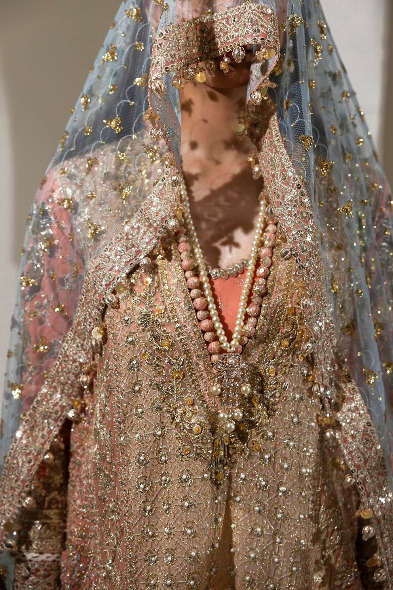 Model wearing a gold and orange Sana Safinaz NURA Festive'24 Vol. II N242 - 002 - 3CX dress with intricate embroidery and a blue dupatta. Perfect for weddings and available online in the UK.